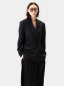 Person wearing a black suit and sunglasses on a white background #color_black