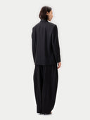 Back view of a person wearing a black suit on a white background #color_black