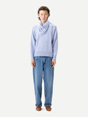 Person wearing a light blue sweater with scarf and jeans on a white background #color_cashmere-blue