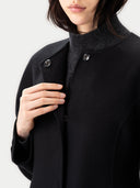 close up of a person wearing a black coat with a white background #color_black