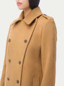 close up of a woman wearing a tan coat with double-breasted buttons on a white background  #color_almond