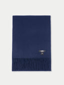 Navy blue scarf with a brand label on a light gray background