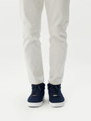 front view of a navy cashmere high-top sneaker matching navy laces, white rubber sole  and white pants #color_navy