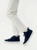 side view of a navy cashmere high-top sneaker matching navy laces, white rubber sole  and white pants #color_navy