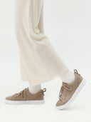 side view of a beige sneakers with white pants #color_taupe