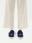 front view of a navy cashmere sneakers with matching navy laces, white rubber soles and white pants, socks  #color_navy