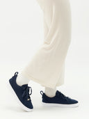 side view of a navy cashmere sneakers with matching navy laces, white rubber soles and white pants, socks  #color_navy