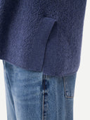 Close-up of a textured blue garment with a pocket detail. #color_crown-blue