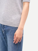 Person wearing a gray shirt and blue jeans on a light gray background #color_vapor-blue