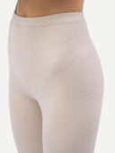 Close up of  beige leggings worn by a person on a white background #color_whisper-white