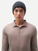 front view of a man wearing a dark gray beanie and a brown polo sweater on a light gray background #color_charcoal