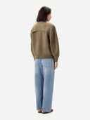 Back view of a person wearing a brown sweater and blue jeans on a white background #color_aloe