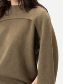 Close up of an olive wool-blend sweater with an architectural double-layer chest detail and dropped shoulders. #color_aloe
