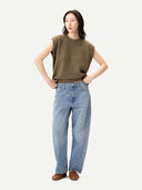 Woman wearing a green sleeveless top and blue jeans on a white background #color_aloe
