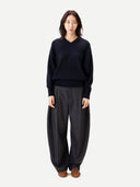 Person wearing a navy sweater and gray pants on a white background #color_charcoal