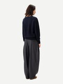 back view of a woman wearing a navy sweater and gray wide-leg pants on a white background #color_charcoal