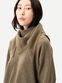 close up of a woman wearing a green sweater and matching with a scarf against a white background. #color_aloe