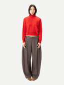 Person wearing a red sweater with collar and brown pants on a white background #color_fiery-red