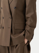 Close up of Brown double-breasted coat with black buttons on a white background #color_sepia