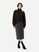 Person wearing a brown sweater and gray skirt on a white background #color_mole