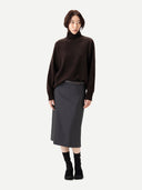Person wearing a brown turtleneck sweater and gray skirt on a white background #color_mole