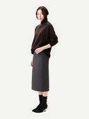 Side view of a woman wearing a brown sweater and gray skirt on a white background #color_mole