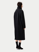 Back view of person wearing a black coat on a white background #color_black