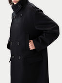 Black coat with a high funnel neck worn by a person on a white background #color_black