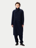 Man wearing a long navy coat on a white background #color_navy-blazer