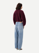 Back view of person wearing a burgundy sweater and light blue jeans on a white background #color_burgundy