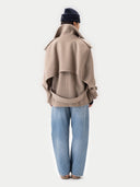 back view of Person wearing a beige coat and blue jeans on a white background #color_taupe