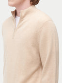 Beige half-zip sweater worn by a person on a light gray background