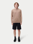 Person wearing a beige sweater and black shorts on a white background. #color_timber-wolf