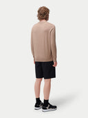 back view of a person wearing a beige sweater and black shorts on a white background. #color_timber-wolf