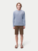 front view of a man wearing a light blue sweater and brown shorts on a white background. #color_celestial-blue