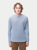 Man wearing a light blue sweater on a white background