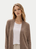 Front view of a woman wearing a brown cardigan over a white shirt on a light background #color_taupe