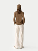 Person wearing a brown sweater and beige pants on a white background #color_lead-gray