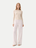 front view of a woman wearing a beige cardigan and light pink pants on a white background. #color_pure-white