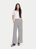 front view of a woman wearing a white top and gray wide-leg pants on a white background  #color_high-rise
