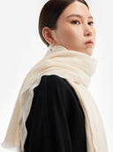 Model wearing the Lightweight Cashmere Woven Scarf in Soft White wrapped at the neck, side view