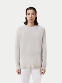 A man wearing a light beige cashmere sweater with a round neckline and long sleeves. #color_silver-birch