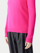 close up of a bright pink sweater and black pants #color_magenta