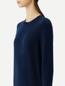 close up of woman a navy crew neck sweater on a light background #color_navy