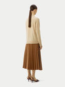 back view of a woman wearing a beige cardigan and brown skirt on a white background #color_beige