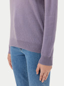 close up side view of a person wearing a light purple sweater and blue jeans on a white background #color_purple-ash