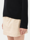 close up of a black long sleeve sweater and beige skirt #color_black