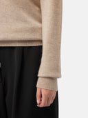 close up bottom side view of a sweater long sleeve and black pants #color_warm-grey