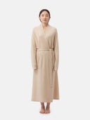 front view of A woman wearing a beige long cashmere robe with a belt, standing against a plain background. #color_beige