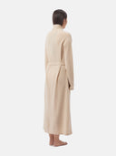 back view of a woman wearing a beige knee-length bathrobe with belt #color_beige